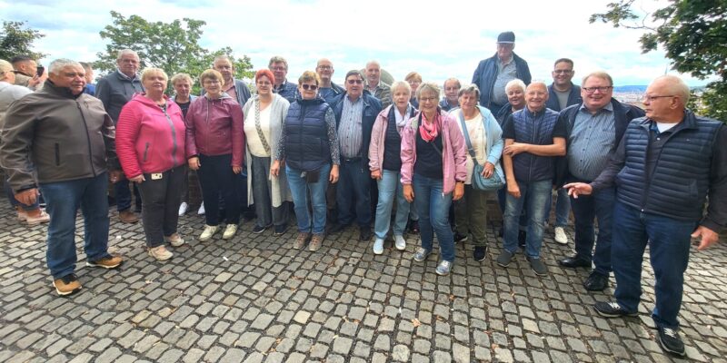 Die 23 Teilnehmer der Soldatenkameradschaft Mellinghausen stehen aufgereiht zum Gruppenfoto vor einer Mauer der Prager Burg